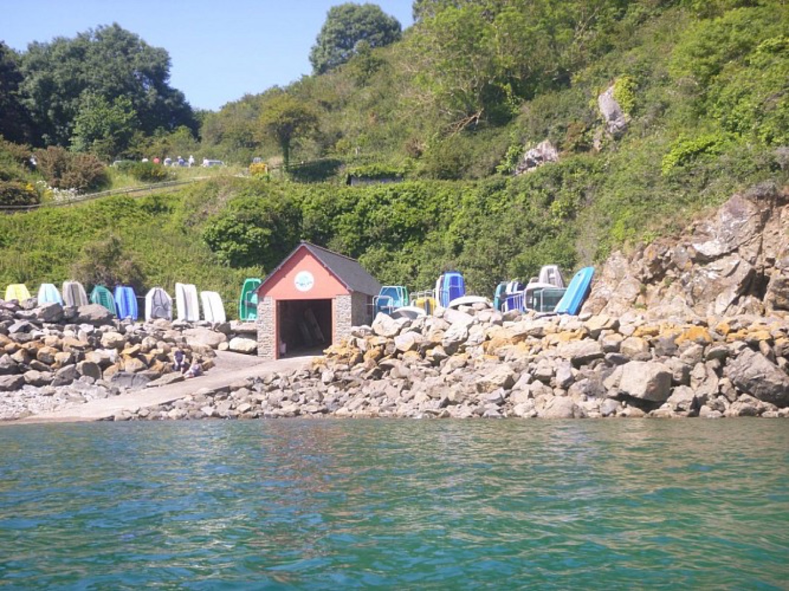 Le cabanon du port de Saint-Géran et ses kayaks colorés sur les galets, crique de baignade à Plévenon